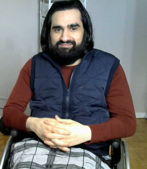 Head shot of Oda Al-anizi. His hands are folded in his lap and he is sitting in a wheelchair. 
